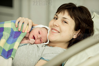 happy woman after birth with a newborn baby
