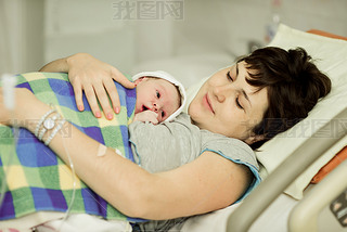 happy woman after birth with a newborn baby