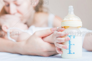 Baby holding a baby bottle with breast milk