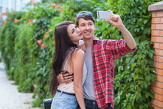 Happy young couple doing selfie by art mobile phone in the city.