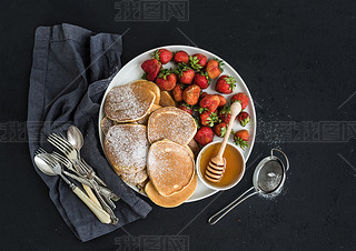 Breakfast plate. Homemade pancakes with fresh strawberry and honey, kitchen napkin, vintage silverwa