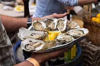 Server with Tray of Fresh Oysters with Lemon