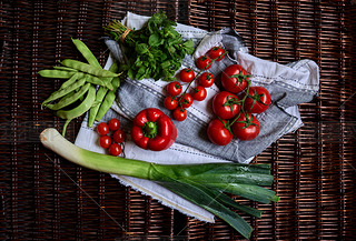 There are vegetables on a dark rattan table