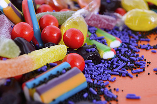 Bright colorful candy on orange wood background.