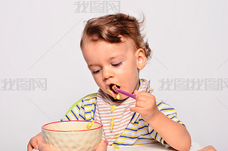 Baby eating food with a spoon, toddler eating messy and getting