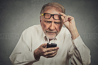 elderly man with glasses hing trouble seeing cell phone