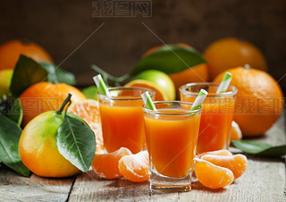 Fresh juice of ripe mandarins in a all glass with striped straws