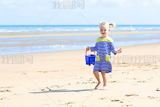 Little girl playing on the beach at summer