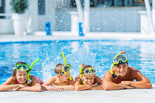 Happy family playing in swimming pool. 