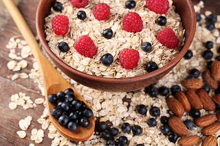 braun Schssel mit Haferflocken und Beeren auf einem Holztisch