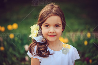 summer outdoor portrait of adorable iling kid girl with yellow flowers on background