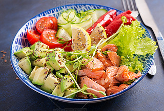 Healthy grilled salmon, ocado, tomato, cucumber, paprika and chia seeds. Balanced lunch in blue bo