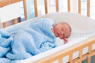 Newborn baby boy in hospital cot