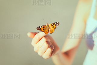 butterfly sitting on the girl hand