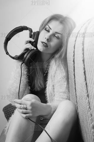 Picture of sexy pretty young lady hing fun enjoying music from headphones. Black and white photogr