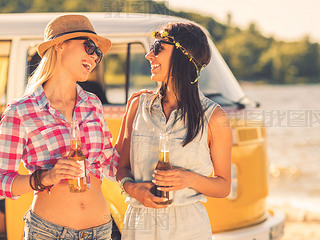 young women holding bottles of beer