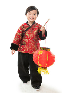 手提灯笼摄影图|一个小男孩手提红色灯笼庆祝新年