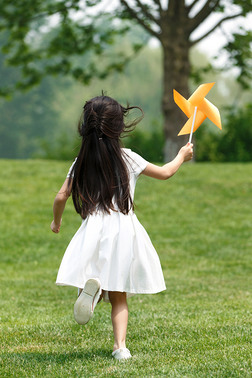 草地背影摄影图|小女孩在草地上玩耍