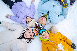 幸福的一家四口躺在雪地上