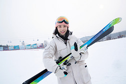 滑雪场上抱着滑雪板的青年女人
