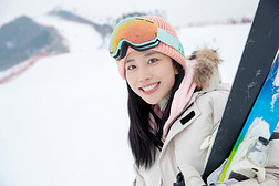 滑雪场上抱着滑雪板漂亮的青年女人