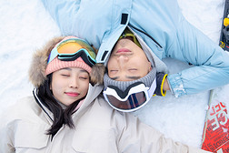 享乐的青年伴侣闭着眼睛躺在雪地上