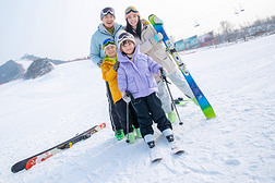 幸福快乐的年轻家庭来滑雪场滑雪