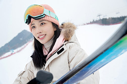 滑雪场上抱着滑雪板漂亮的青年女人