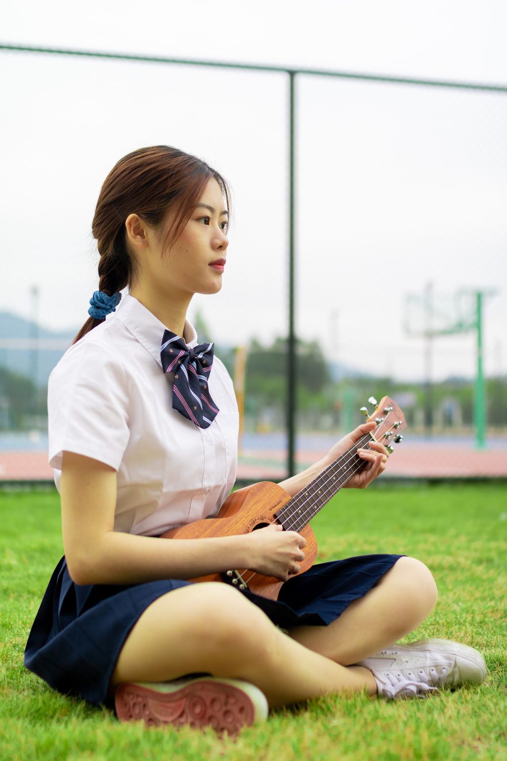 户外青年女子草地上弹尤克里里