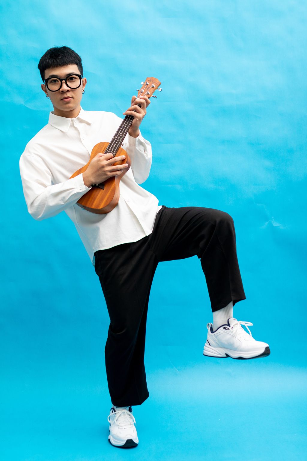 弹尤克里里的青年男子男性人像棚拍