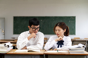 青春男女情侣大学生在校园教室里学习