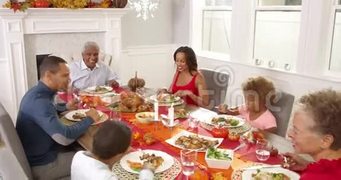镜头跟踪显示大家庭围坐在餐桌旁吃感恩节大餐