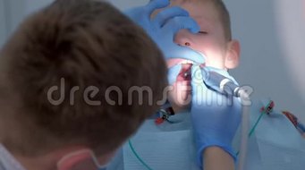 牙医卫生员在牙科为少年儿童做口腔卫生清洁