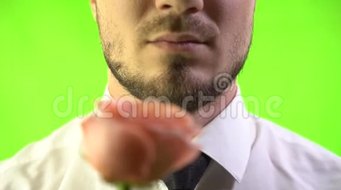 在绿色屏幕背景下特写脸部男士嗅到玫瑰