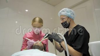女牙医助理做男性病人在牙科中清洁牙齿