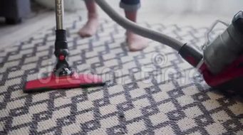 年轻女子用吸尘器清洁地毯