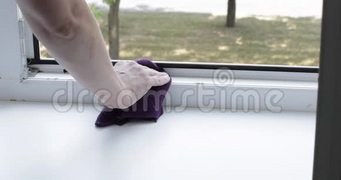 女人用湿布清洁窗台