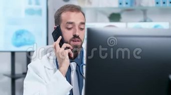 一张年轻医生在电话中交谈的手持照片